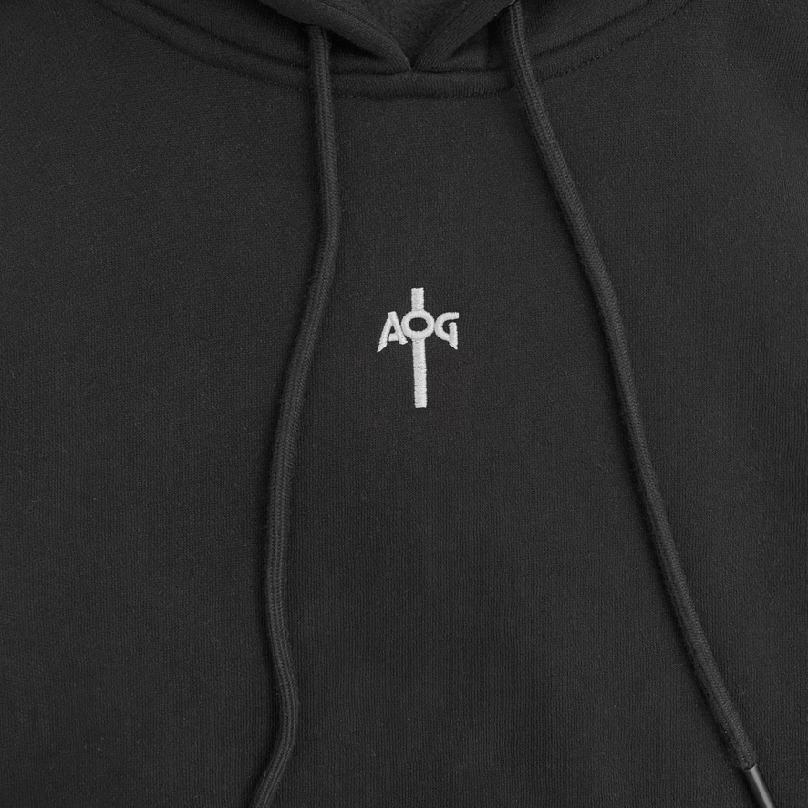 Close-up of the embroidered AOG cross monogram on the chest